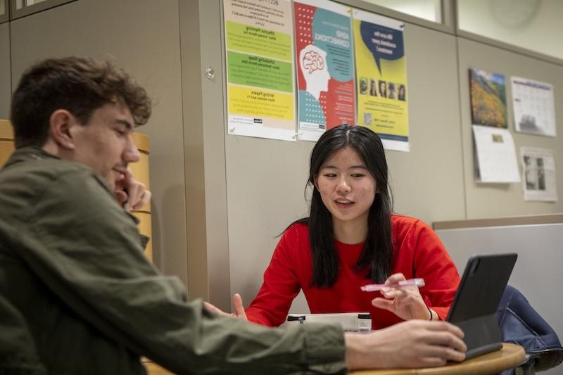 Two students chatting at a table